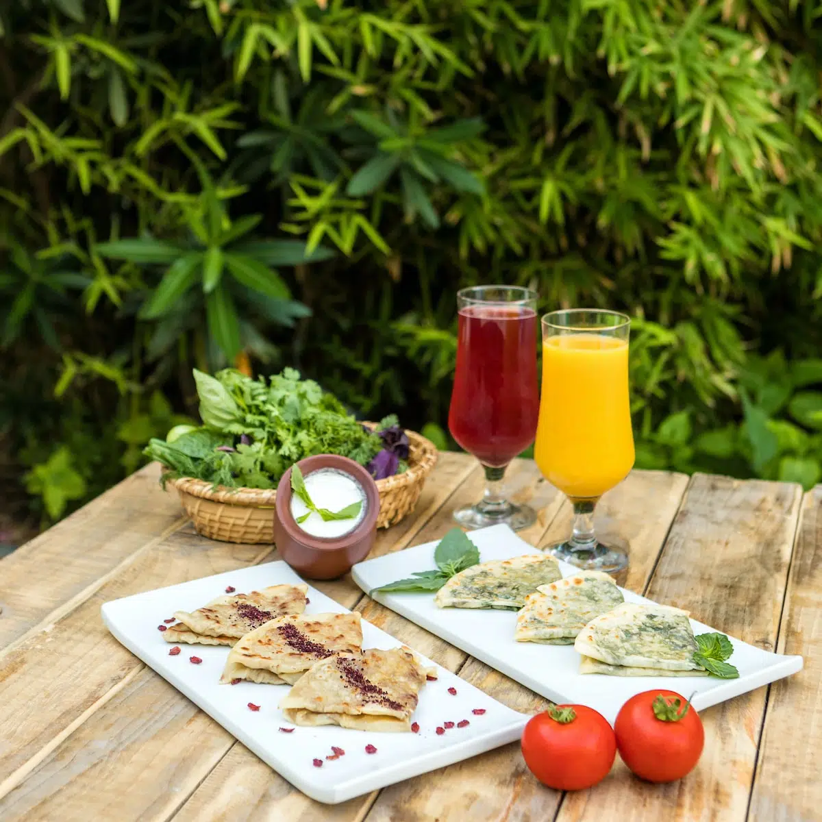 sliced tomato on white ceramic plate beside clear drinking glass with orange juice